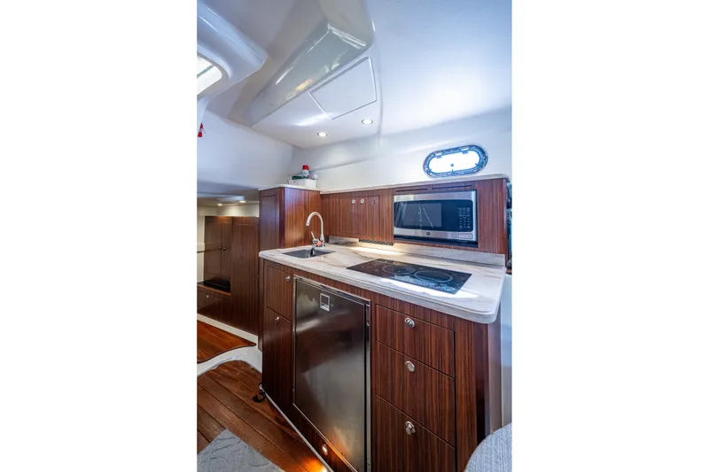 Slide: The Image of Luxurious 2020 Pursuit OS 355 Offshore yacht kitchen with modern appliances and wood cabinetry. - 54