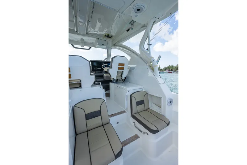 Slide: The Image of 2020 Pursuit OS 355 Offshore boat interior with seating and helm, overlooking the ocean. - 30