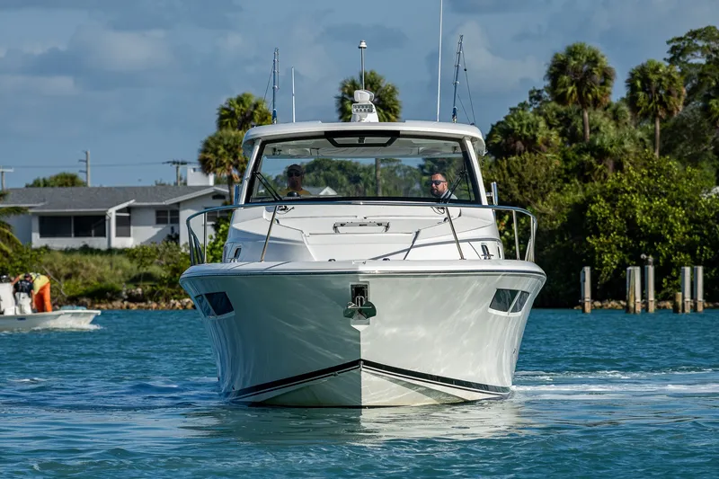 Slide: The Image of 2020 Pursuit OS 355 Offshore boat cruising on a sunny day near a coastal area. - 15