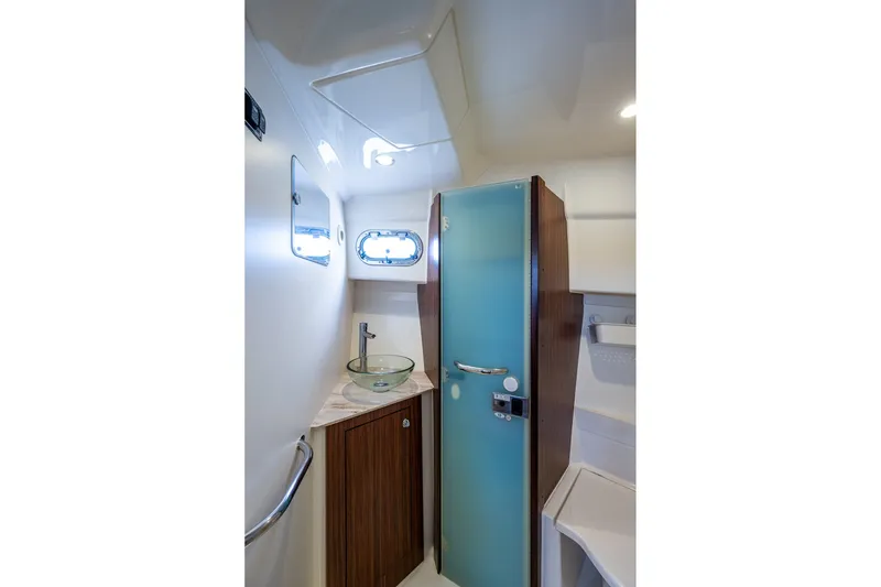 Slide: The Image of 2020 Pursuit OS 355 Offshore boat bathroom with glass sink and frosted door. - 58