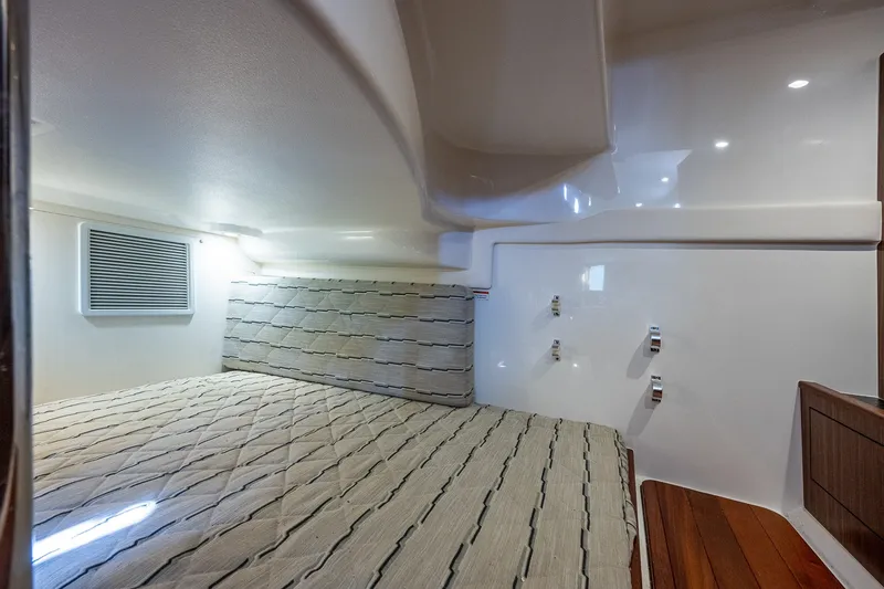 Slide: The Image of Interior cabin of 2020 Pursuit OS 355 Offshore boat, featuring a cozy bed and modern design. - 61