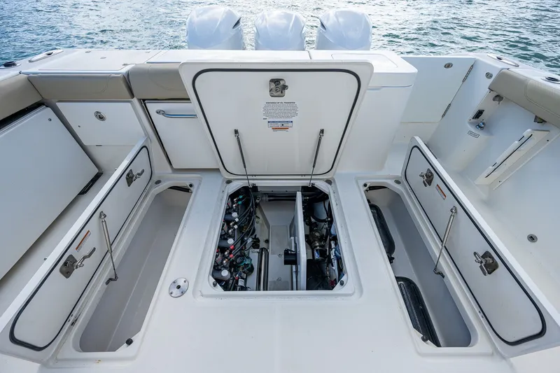 Slide: The Image of 2020 Pursuit OS 355 Offshore boat with open storage compartments and engine access. - 44