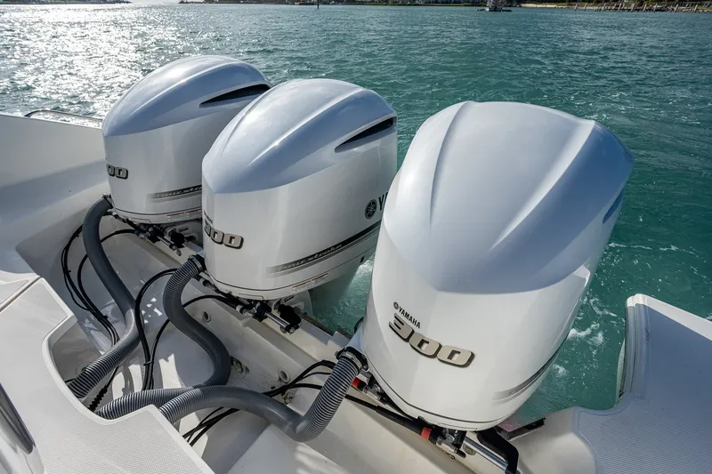 Slide: The Image of Triple Yamaha 300 engines on a 2020 Pursuit OS 355 Offshore boat in water. - 45