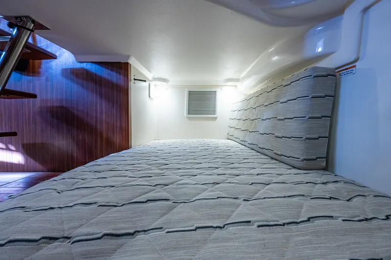 Slide: The Image of 2020 Pursuit OS 355 Offshore cabin interior with cozy bedding and wooden accents. - 63