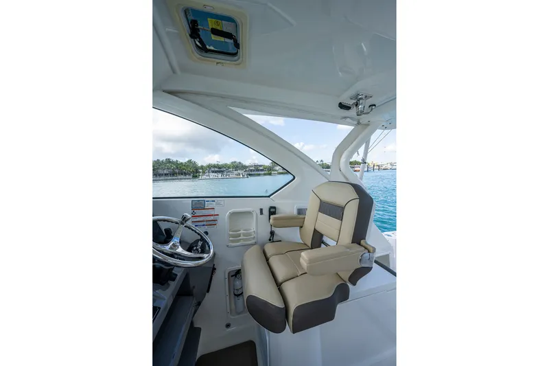 Slide: The Image of Captain's seat on 2020 Pursuit OS 355 Offshore boat, overlooking serene waters. - 39