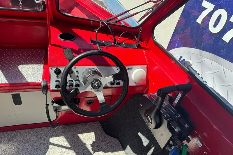 Slide: The Image of Red KingFisher 2025 Discovery boat dashboard with steering wheel and controls, 2016 model. - 17
