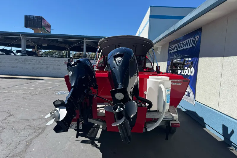 Slide: The Image of Red KingFisher 2025 Discovery boat with dual outboard motors parked outside a building. - 7