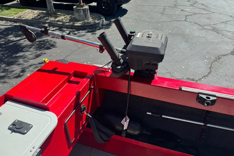 Slide: The Image of Red KingFisher 2025 Discovery boat with fishing rod holder, parked on asphalt. - 27