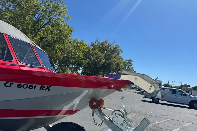 Slide: The Image of Red and silver KingFisher 2025 Discovery boat on trailer, parked under clear blue sky. - 5