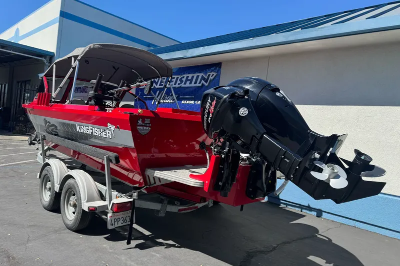 Slide: The Image of Red 2016 KingFisher 2025 Discovery boat on trailer, parked outside a building. - 9