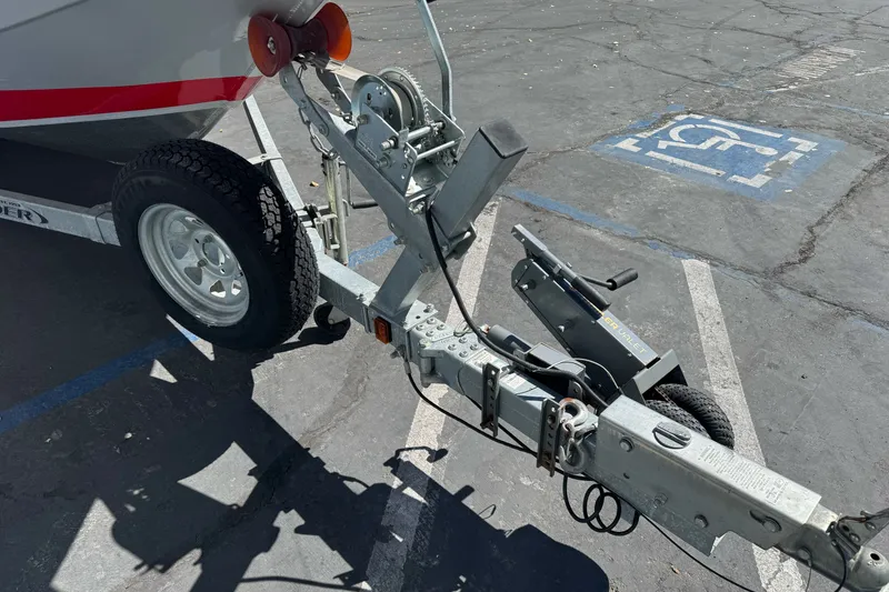 Slide: The Image of Trailer hitch of a 2016 KingFisher 2025 Discovery boat in a parking lot. - 2