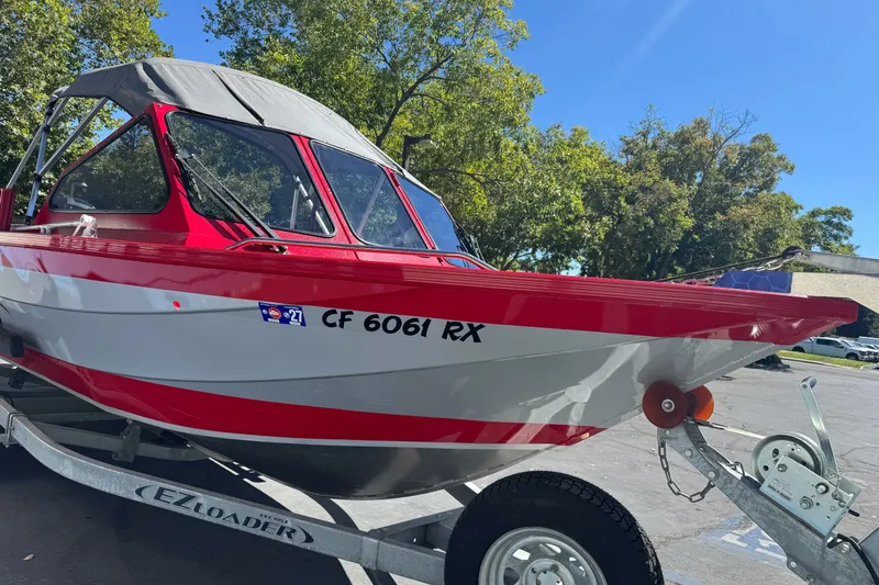 Slide: The Image of Red and white 2016 KingFisher 2025 Discovery boat on trailer, parked outdoors. - 4