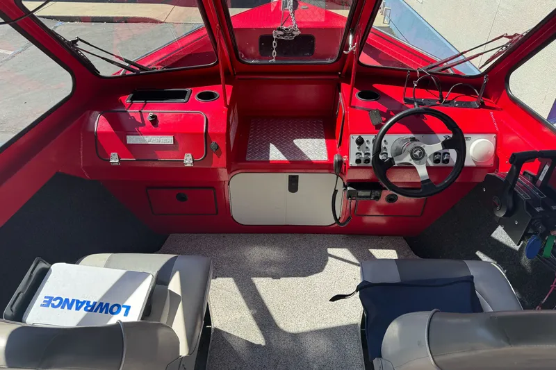 Slide: The Image of Interior of a 2016 KingFisher 2025 Discovery boat with red dashboard and steering wheel. - 13