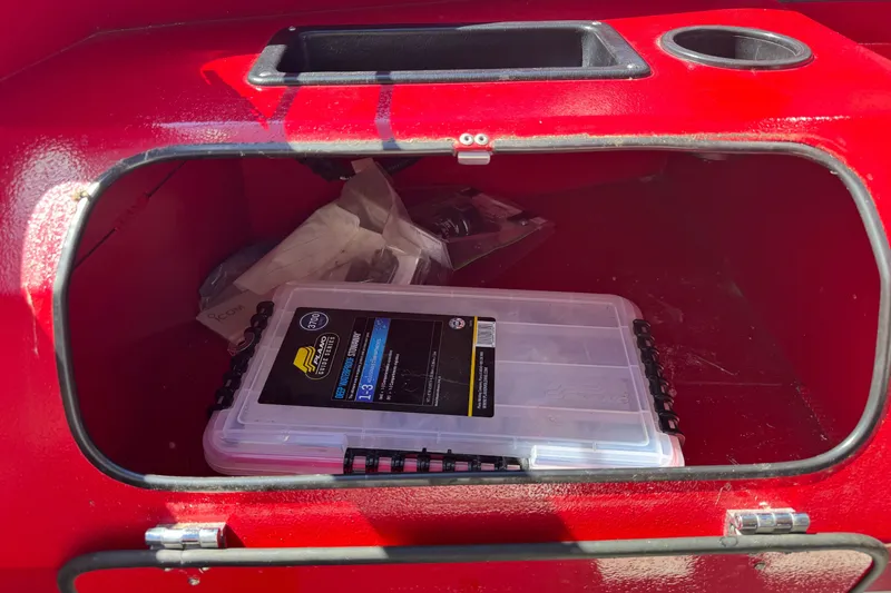 Slide: The Image of Red storage compartment in KingFisher 2025 Discovery boat, containing a plastic organizer box. - 21