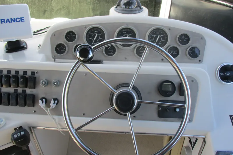 Slide: The Image of Steering wheel and dashboard of 1995 Bayliner 3258 Avanti boat, featuring gauges and controls. - 20