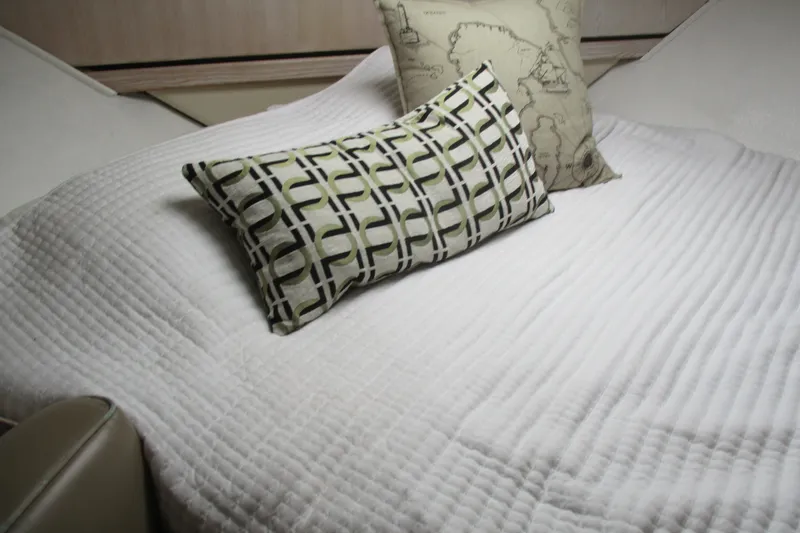 Slide: The Image of Interior of 1995 Bayliner 3258 Avanti with decorative pillows on a white bedspread. - 42