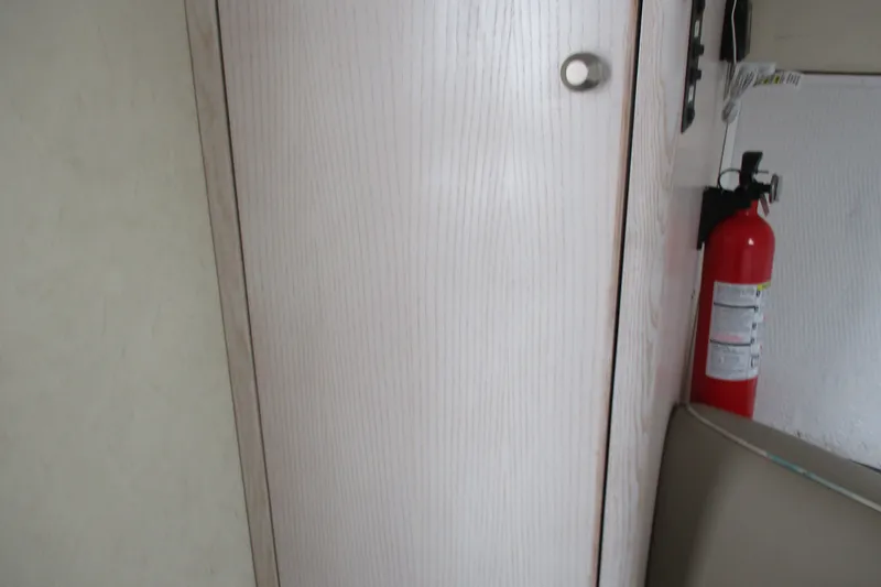 Slide: The Image of Interior of 1995 Bayliner 3258 Avanti with fire extinguisher and wooden cabinet. - 45