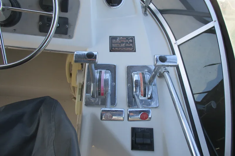 Slide: The Image of Control panel of a 1995 Bayliner 3258 Avanti boat, featuring steering wheel and throttle levers. - 21