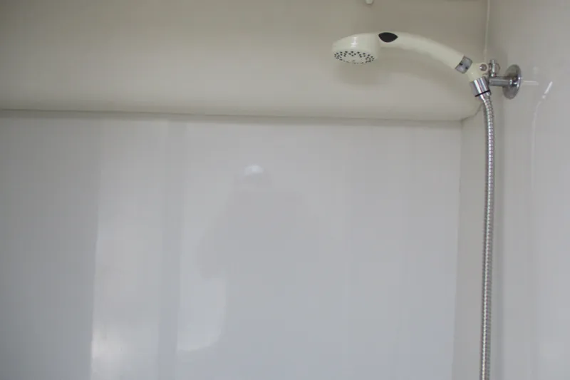 Slide: The Image of Shower area inside 1995 Bayliner 3258 Avanti boat, featuring a flexible hose and showerhead. - 49