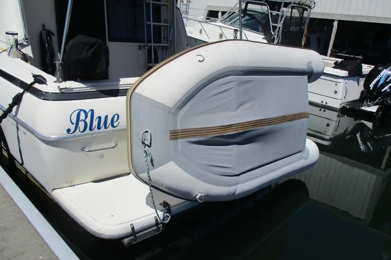 Slide: The Image of 1995 Bayliner 3258 Avanti with inflatable dinghy attached at the stern, docked in a marina. - 8