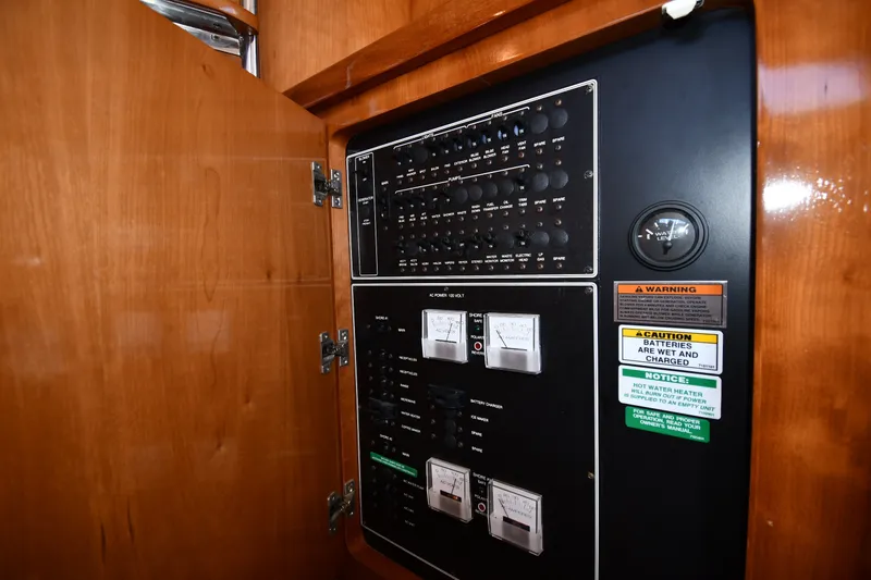 Slide: The Image of Electrical panel inside a 2002 Carver 350 Mariner yacht, featuring gauges and warning labels. - 50