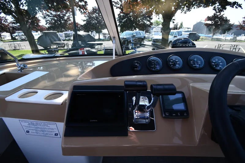 Slide: The Image of 2002 Carver 350 Mariner helm with gauges, controls, and Garmin navigation system. - 19