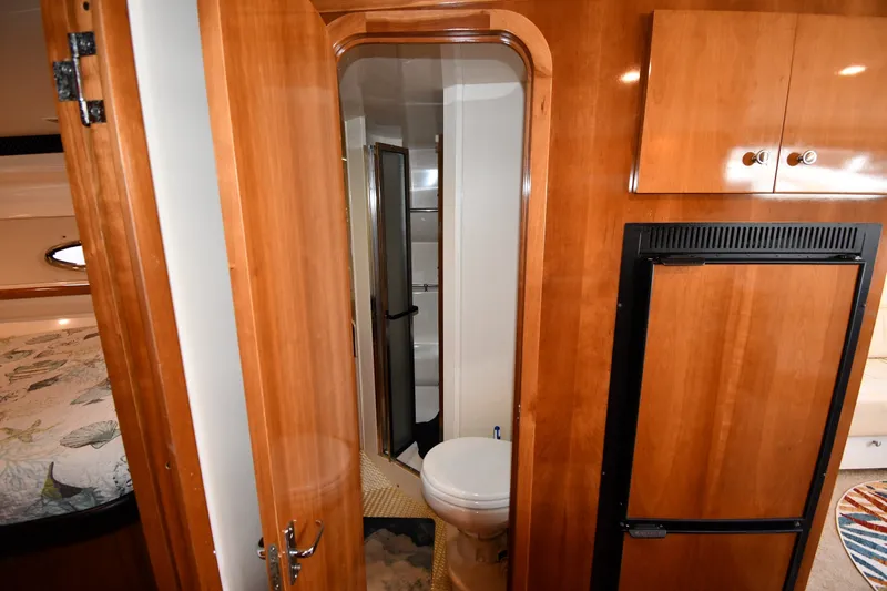 Slide: The Image of Interior of 2002 Carver 350 Mariner yacht showing bathroom, wooden cabinetry, and refrigerator. - 35