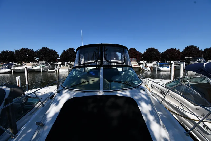 Slide: The Image of 2002 Carver 350 Mariner yacht docked at a marina under clear blue skies. - 6