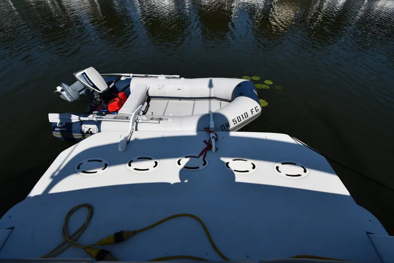 Slide: The Image of 2002 Carver 350 Mariner with Zodiac inflatable boat on calm water. - 49