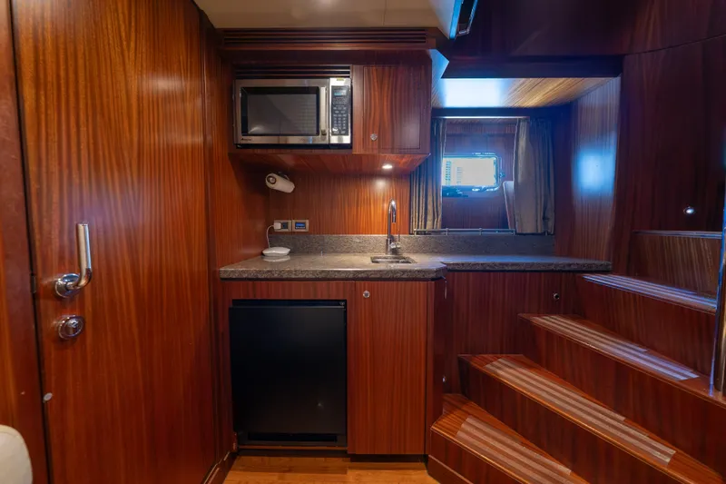Slide: The Image of Luxurious kitchenette in 2013 Ocean Alexander 90 Skylounge Motoryacht with wood finish and modern appliances. - 46