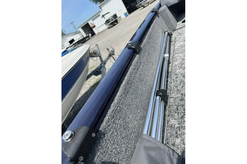 Slide: The Image of 2025 Tracker Pro Guide V-175 SC boat interior with rod holders and carpeted flooring. - 19