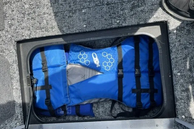 Slide: The Image of Blue life jacket stored in a compartment of a 2025 Tracker Pro Guide V-175 SC boat. - 23