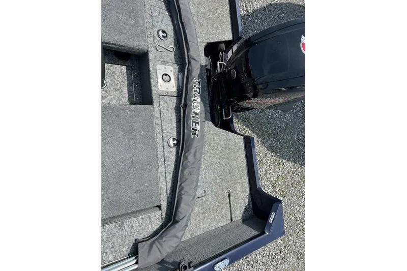 Slide: The Image of 2025 Tracker Pro Guide V-175 SC boat interior with motor, featuring gray carpeting and branding. - 7