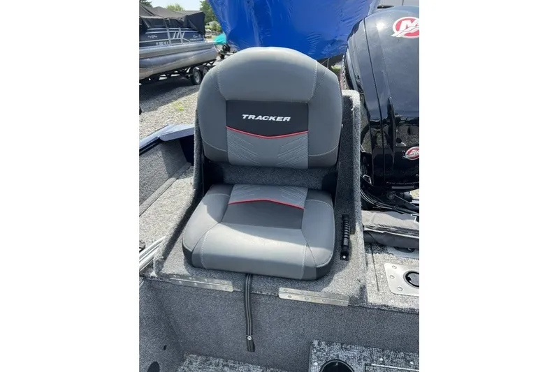 Slide: The Image of 2025 Tracker Pro Guide V-175 SC boat seat, gray with red accents, outdoor setting. - 28