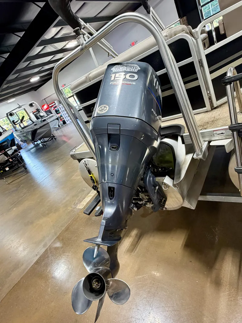Slide: The Image of An outboard motor is attached to a pontoon boat in a showroom setting. - 11