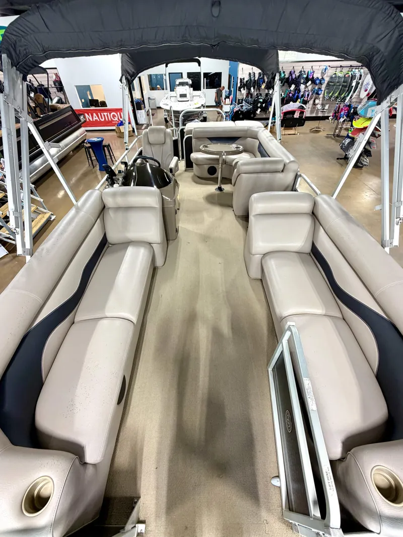 Slide: The Image of The image shows the interior of a Premier Sunsation 220 pontoon boat with beige seating and a black canopy. - 5
