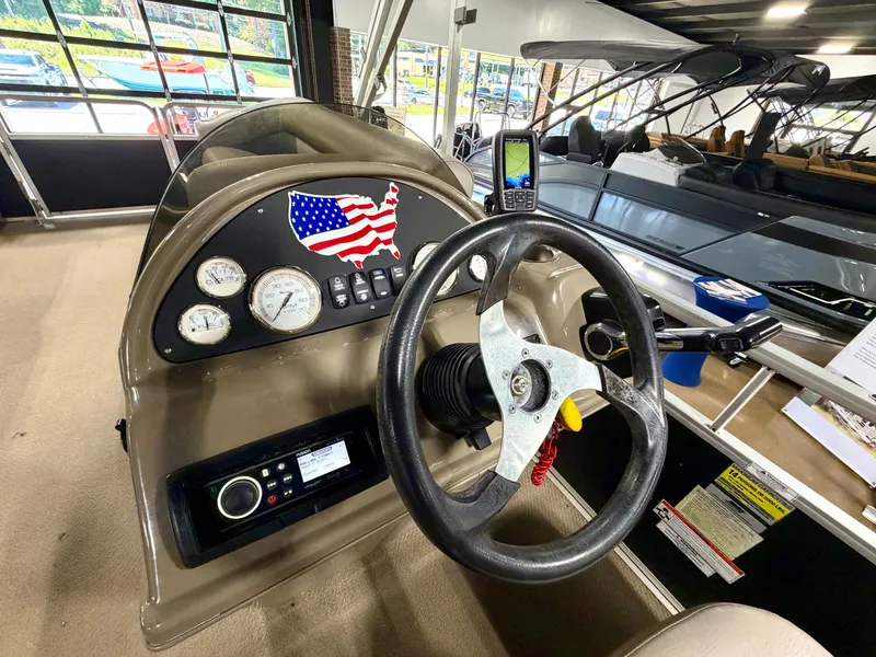 Slide: The Image of The image shows the helm of a 2011 Premier Sunsation 220 boat with a steering wheel and gauges. - 8