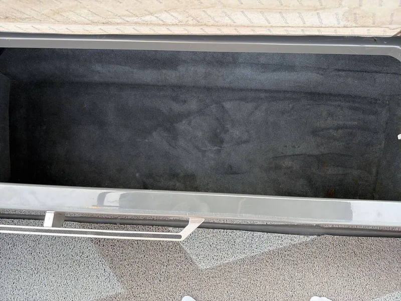 Slide: The Image of An empty, rectangular storage compartment with dark carpet lining. - 29