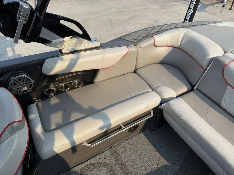 Slide: The Image of The 2015 MasterCraft X30 features a sleek, cushioned seating area with speakers and cup holders. - 24
