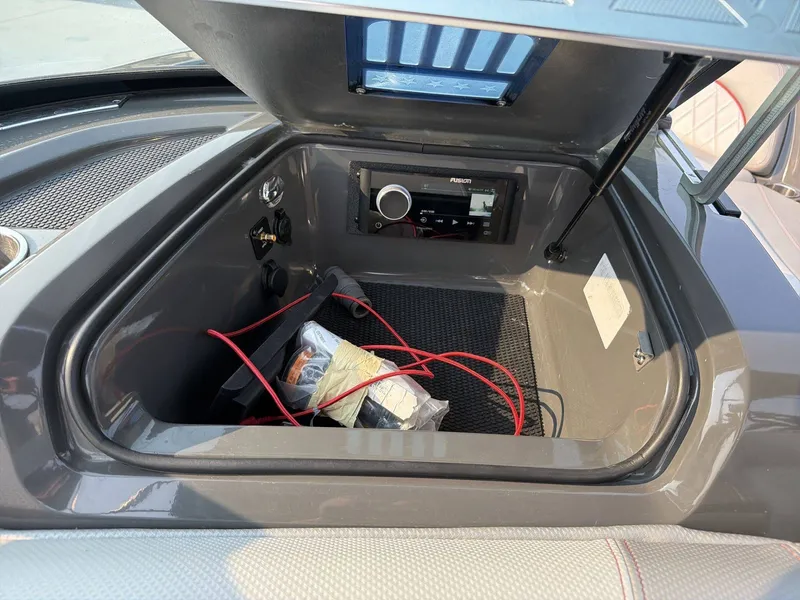 Slide: The Image of An open storage compartment in a boat with a radio and wires inside. - 13
