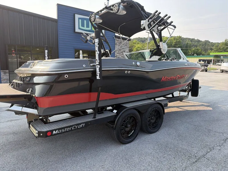 Slide: The Image of A 2015 MasterCraft X30 boat on a trailer in front of a building. - 28