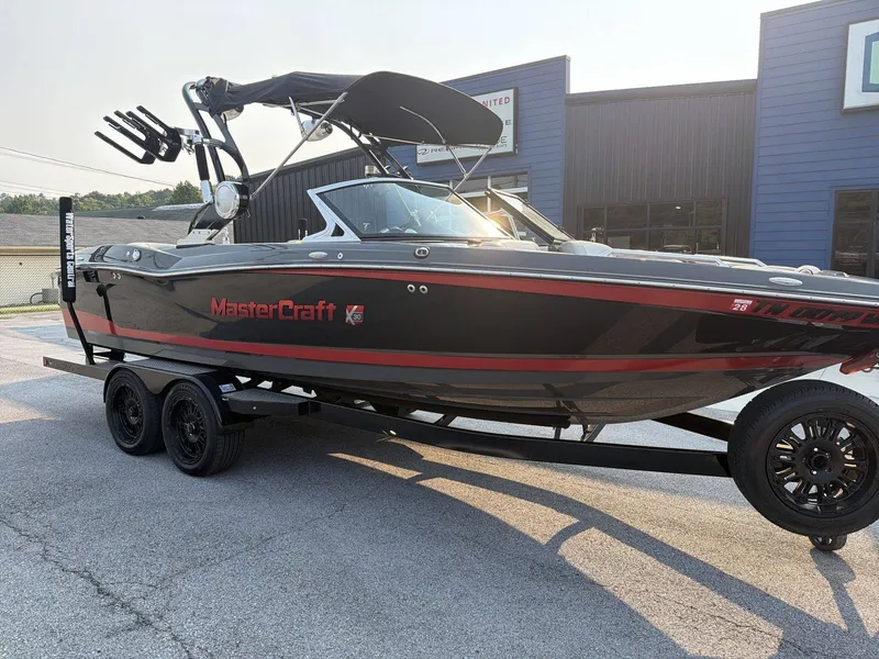 Slide: The Image of A black 2015 MasterCraft X30 boat on a trailer in front of a building. - 3