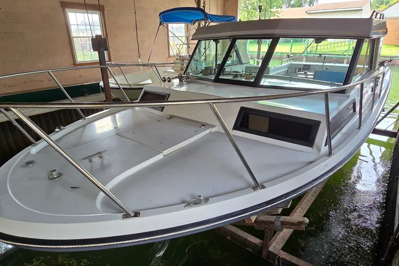 Slide: The Image of 1989 SportCraft 270 Fisherman boat docked indoors, showcasing spacious deck and cabin. - 4