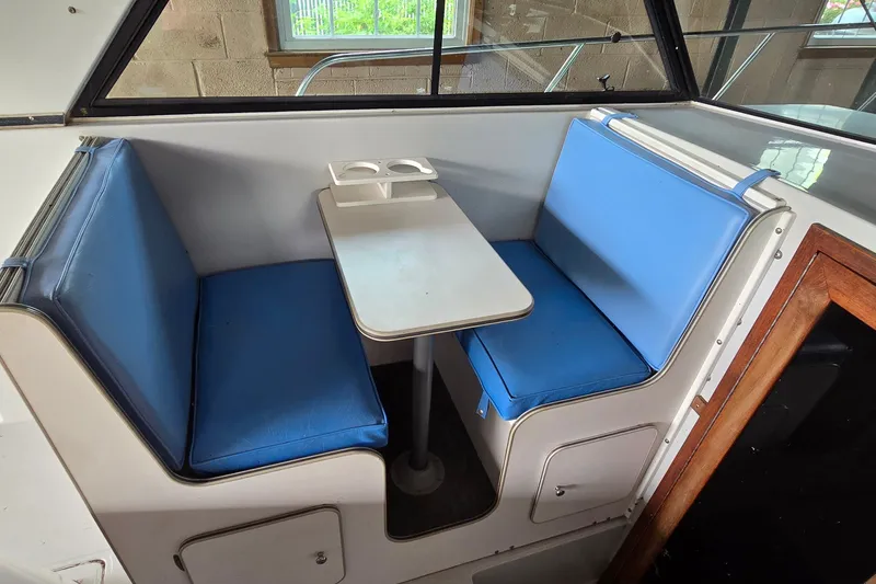 Slide: The Image of 1989 SportCraft 270 Fisherman boat interior with blue cushioned seating and table. - 11