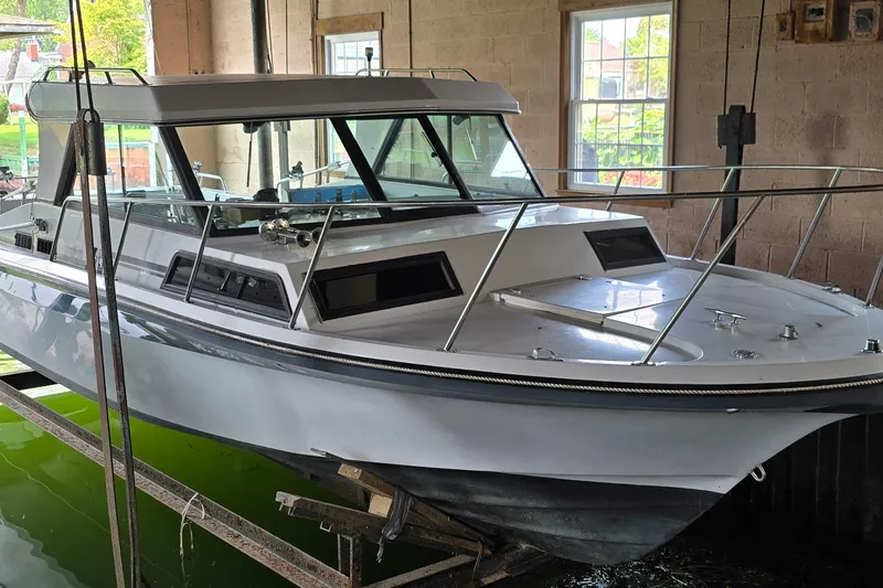 Slide: The Image of 1989 SportCraft 270 Fisherman boat in a boathouse, partially submerged in water. - 2