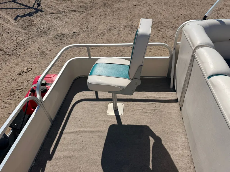 Slide: The Image of A boat with a swivel seat on a carpeted floor. Sandy ground in the background. - 34