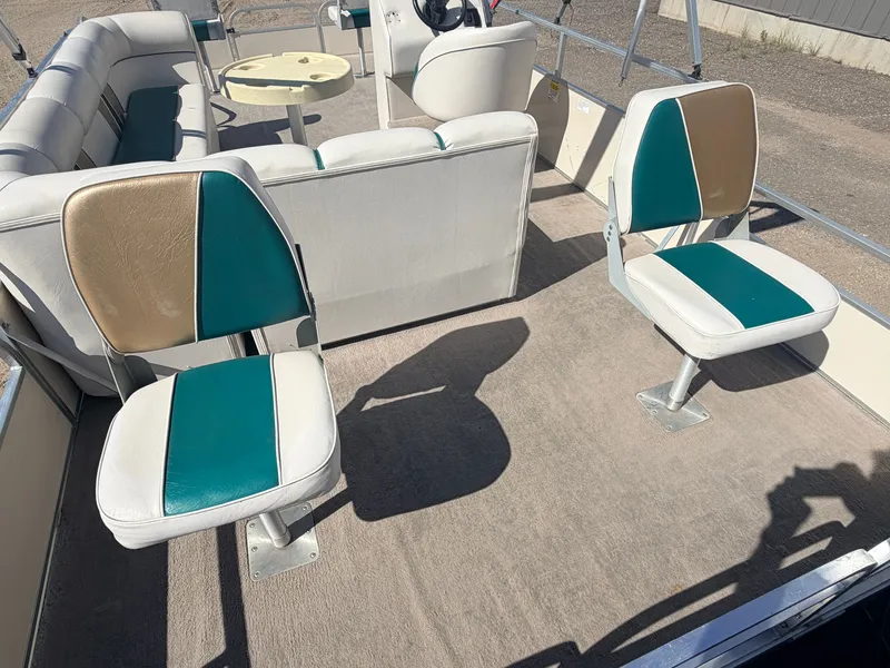Slide: The Image of The image shows the deck of a pontoon boat with two swivel seats in beige and turquoise. - 32