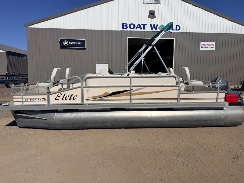 Slide: The Image of A 2006 Elete pontoon boat is on dry land in front of a building labeled "Boat World." - 43