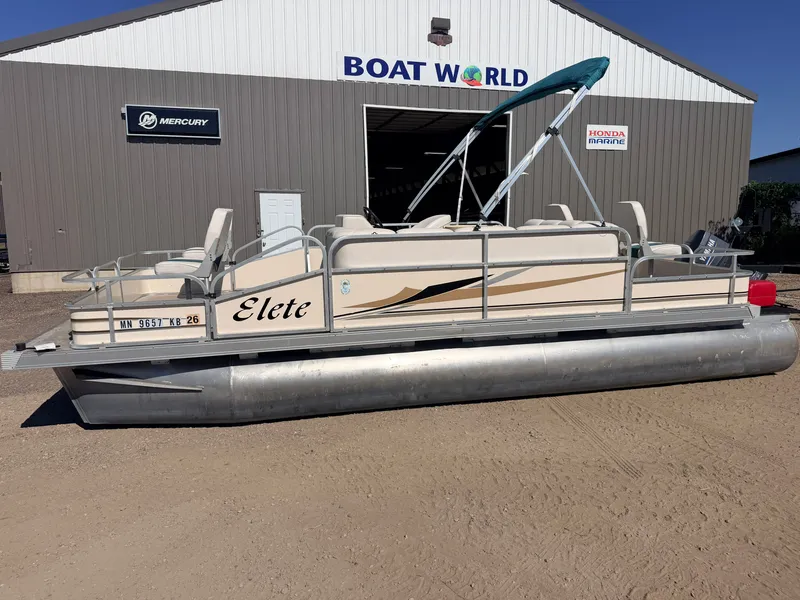 Slide: The Image of A 2006 Elete pontoon boat with a 50HP Yamaha engine, parked in front of a boat dealership. - 22