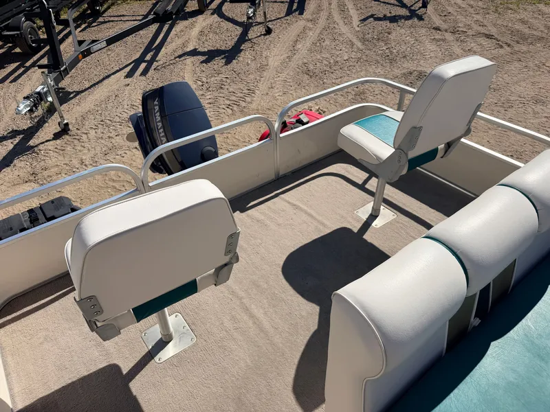 Slide: The Image of A pontoon boat with two swivel seats and a Yamaha outboard motor on sandy ground. - 33